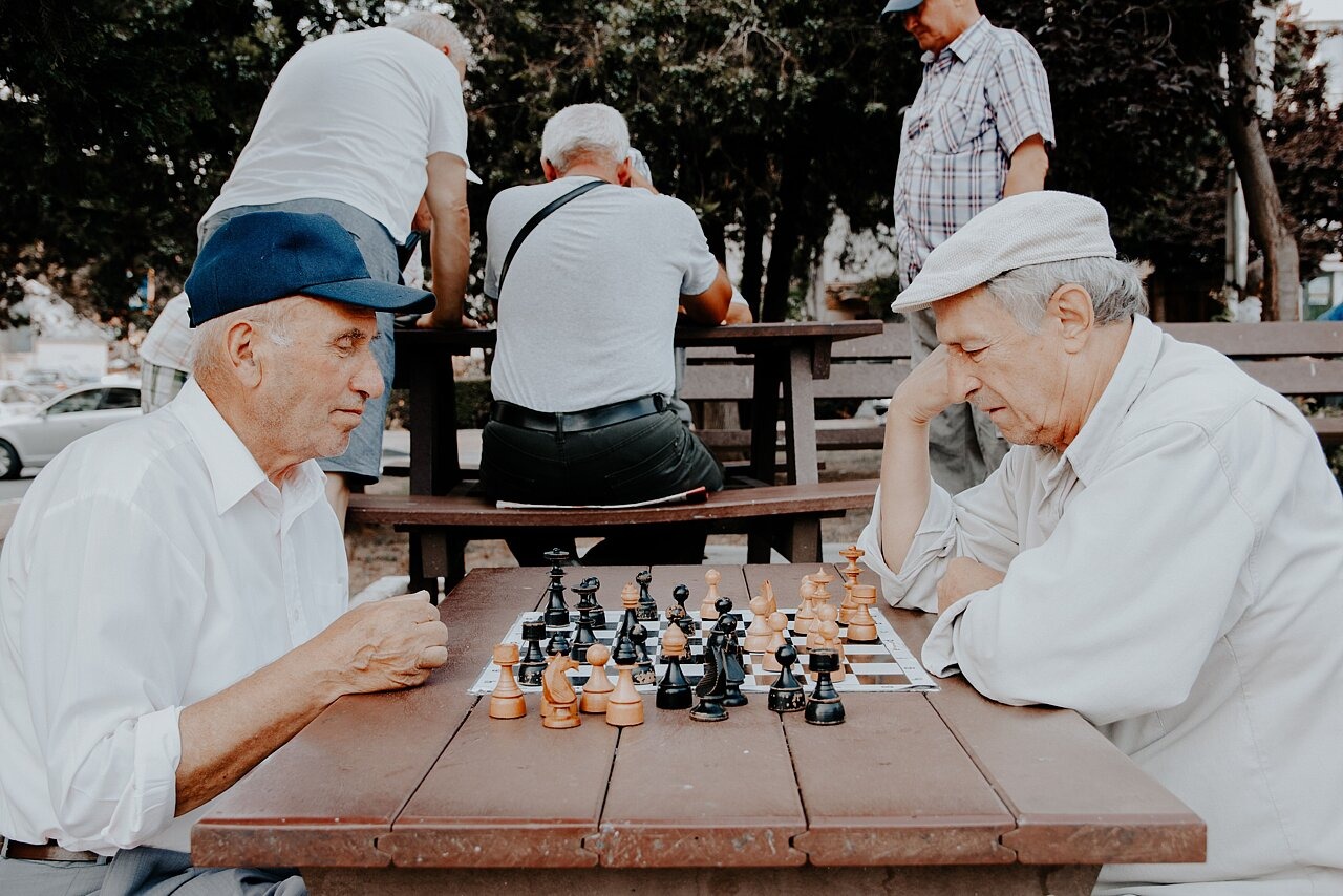 Zwei Männer spielen draußen Schach.