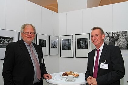 16.	Foto zeigt zwei Männer im Gespräch an einem Stehtisch